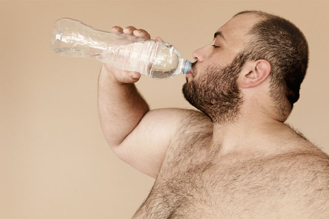 A fat person drinking water