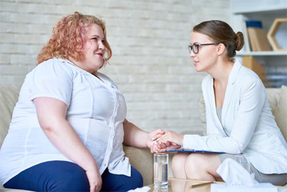 A caregiver talking to an obese person